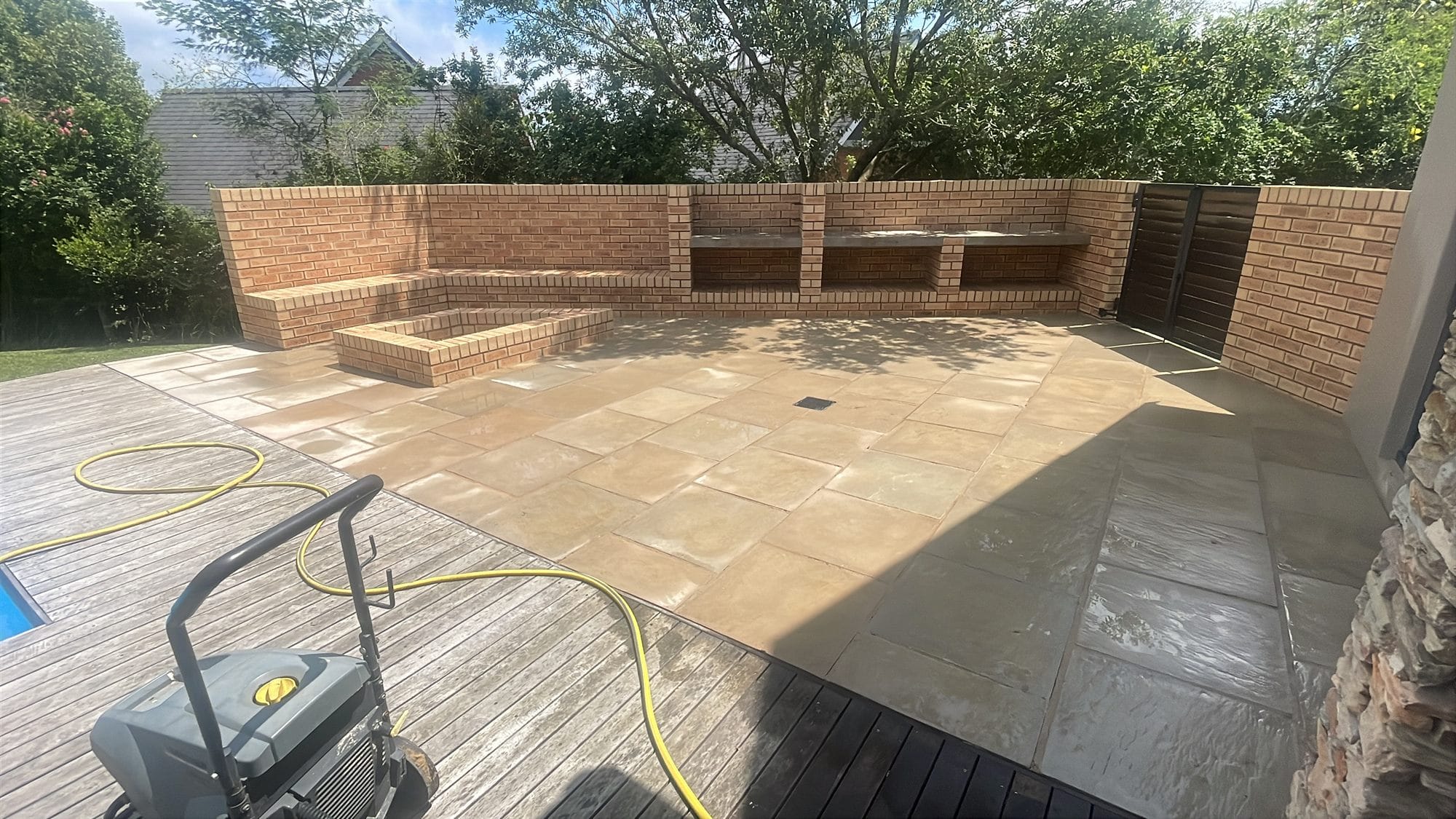 Sandstone patio hi-pressure clean showing clean and dirty split